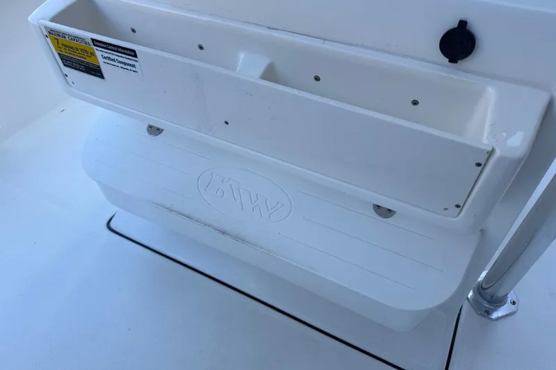 Slide: The Image of 2026 Key West 219 FS boat interior with storage compartment and KW logo. - 27