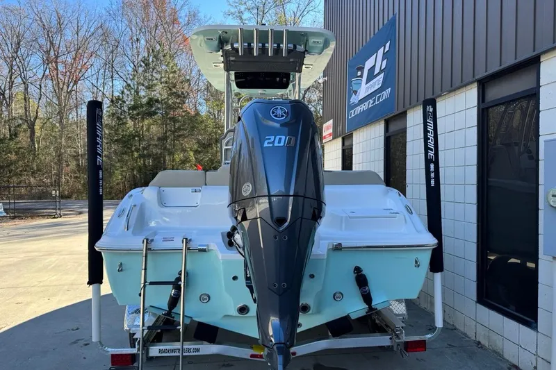 Slide: The Image of 2026 Key West 219 FS boat with Yamaha 200 engine, parked outside a marine shop. - 5
