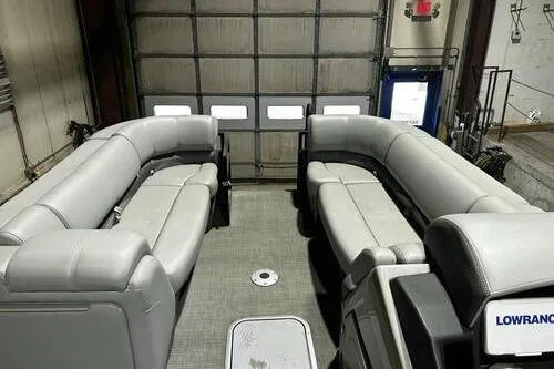 Slide: The Image of 2025 Regency 230 DL3 pontoon boat interior with gray seating in a garage. - 6