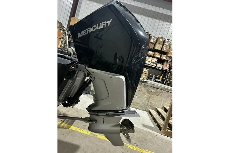 Slide: The Image of Outboard motor on a 2025 Regency 230 DL3 boat in a warehouse setting. - 9