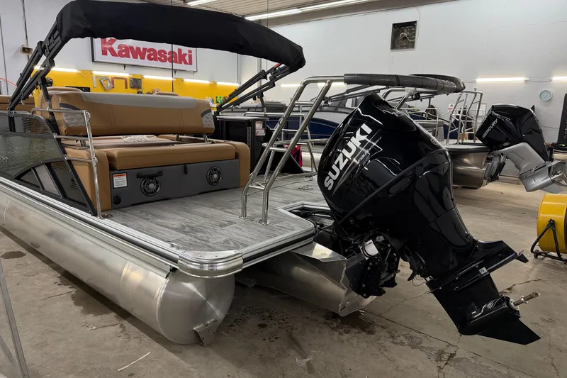 Slide: The Image of 2025 Crest Classic 220 SLSC pontoon boat with Suzuki outboard motor in showroom. - 10