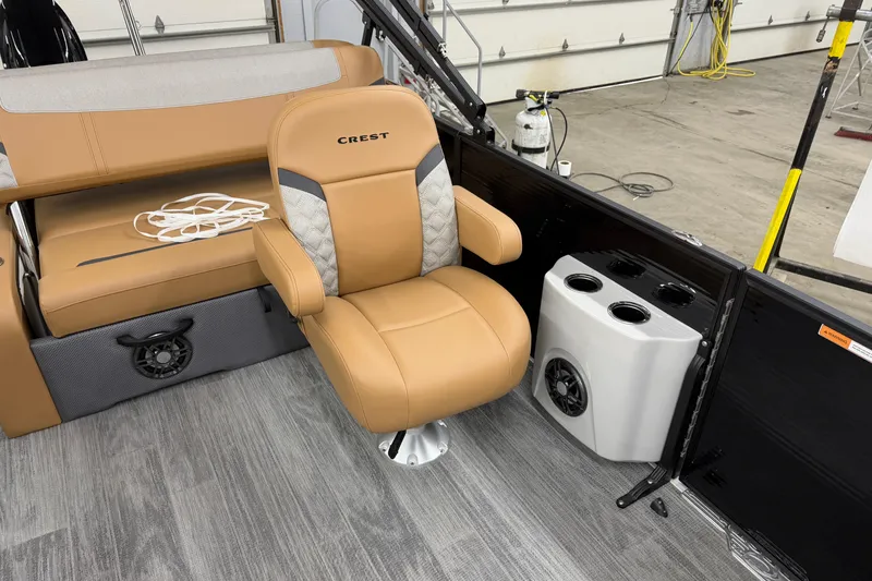 Slide: The Image of 2025 Crest Classic 220 SLSC boat interior with tan seating and cup holders. - 5
