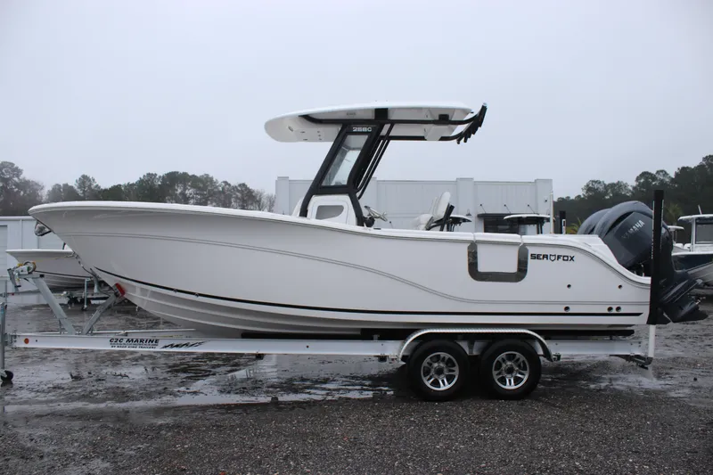 The Image of 2026 Sea Fox 268 Commander boat on trailer, side view, in a marina setting. - 0