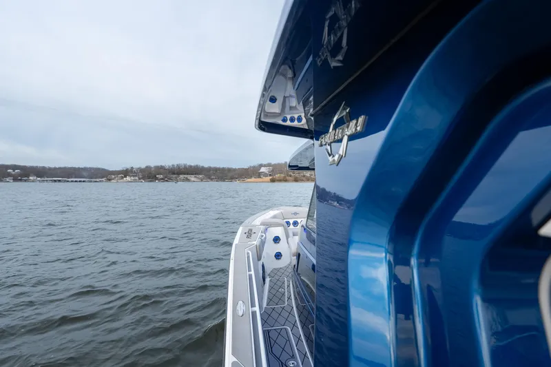 Slide: The Image of 2026 Fountain 38 SCX boat on water, showcasing sleek blue design and spacious deck. - 31