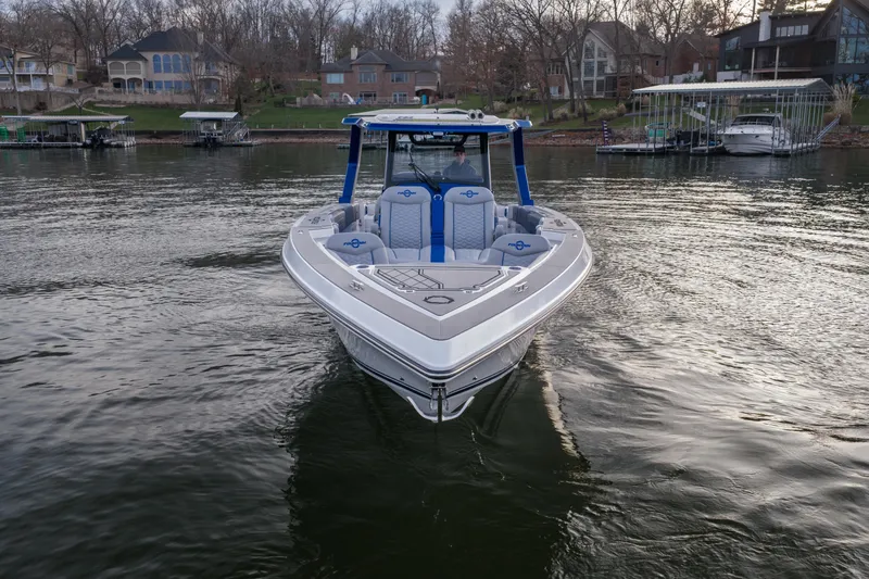 Slide: The Image of 2026 Fountain 38 SCX boat on a calm lake near waterfront homes. - 4