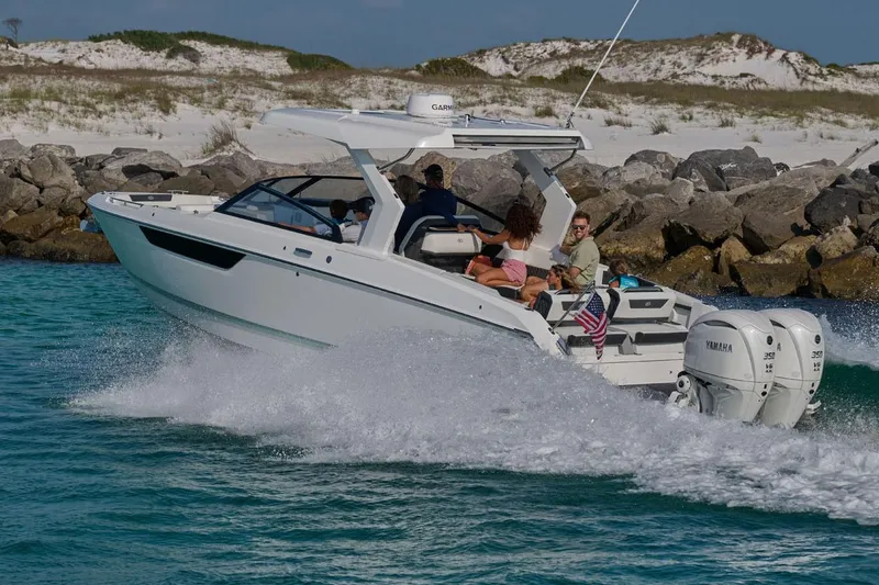 Slide: The Image of Manufacturer Provided Image: 2026 Cobalt R31 OB boat cruising in clear blue water near rocky shoreline. - 3