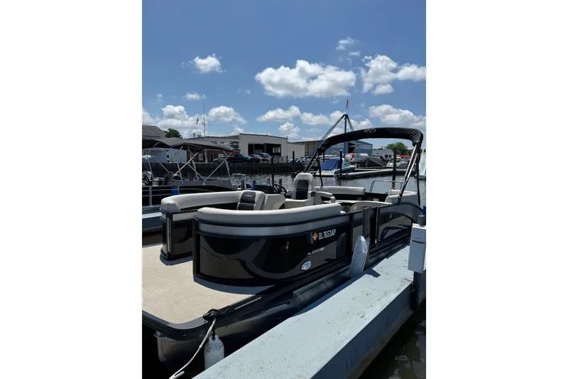 The Image of 2024 Harris Breeze 230 pontoon boat docked under a clear blue sky. - 1