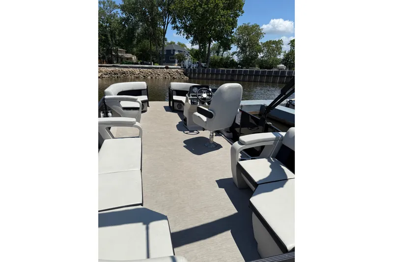 Slide: The Image of 2024 Harris Breeze 230 pontoon boat interior with spacious seating and steering console. - 3