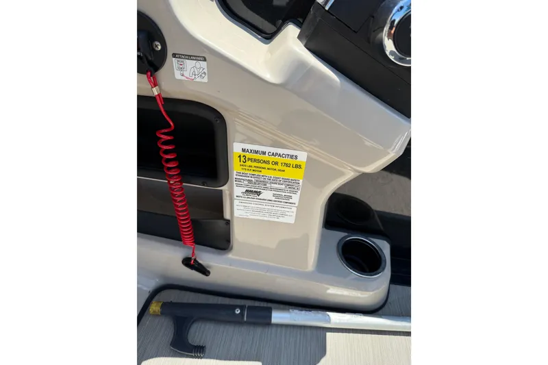 Slide: The Image of 2024 Harris Breeze 230 boat console with capacity label and safety lanyard. - 7