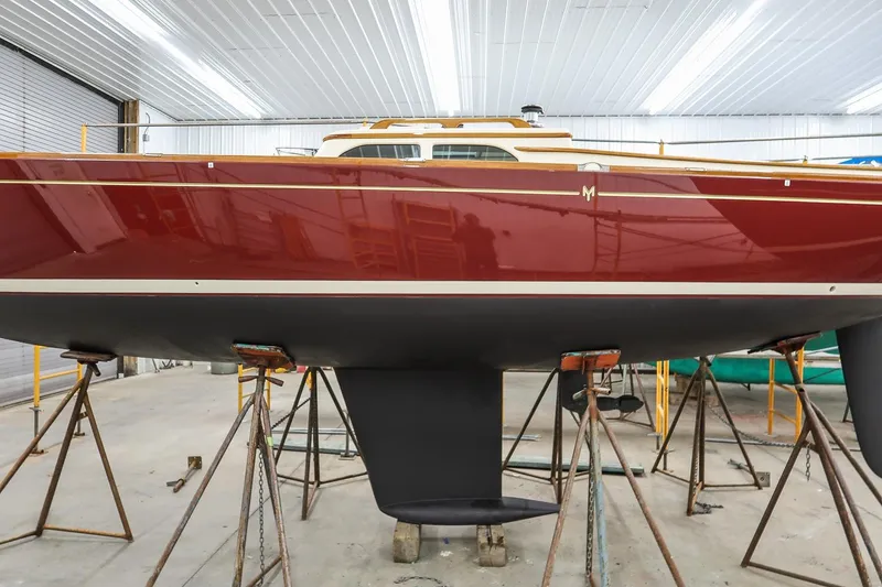 Slide: The Image of 2011 Morris M29 sailboat in a workshop, elevated on stands for maintenance. - 4