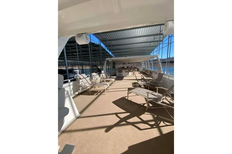 Slide: The Image of Spacious deck of 2007 Summerset houseboat with lounge chairs under a covered area. - 122