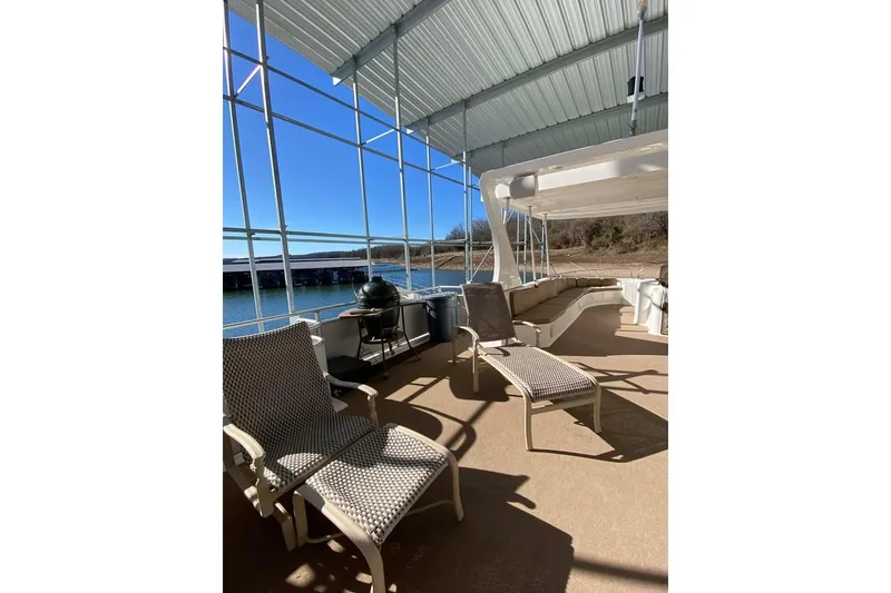 Slide: The Image of Spacious deck of 2007 Summerset houseboat, featuring lounge chairs under a covered area. - 125