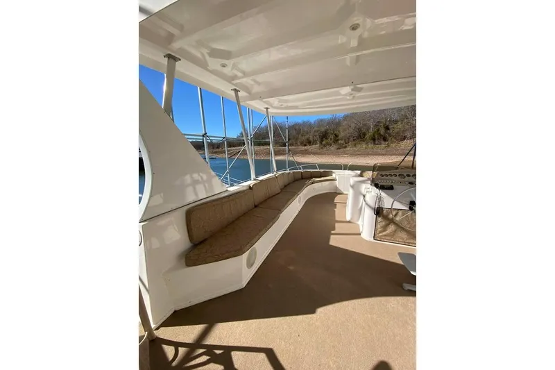 Slide: The Image of Outdoor seating area on 2007 Summerset houseboat, featuring chairs and tables under a covered deck. - 131