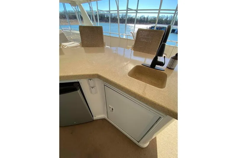 Slide: The Image of Summerset 21' x 106' 2007 houseboat interior with mounted TV and lake view. - 144
