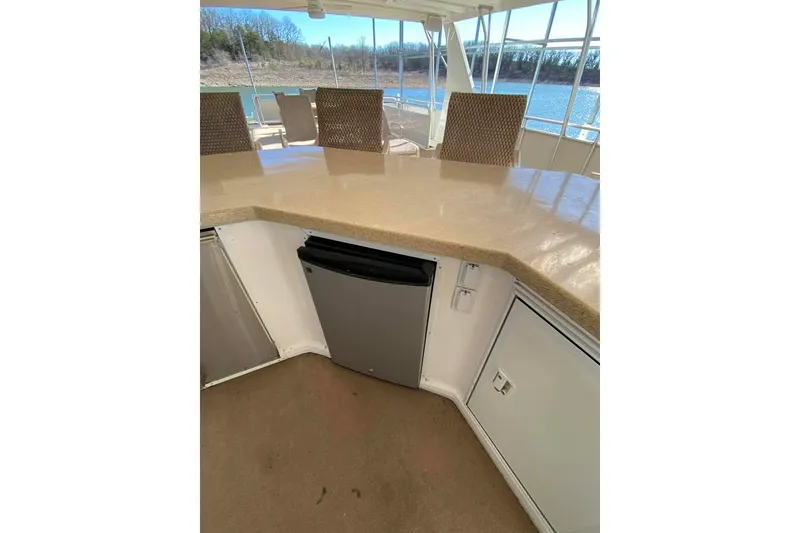 Slide: The Image of Outdoor seating area on 2007 Summerset houseboat, featuring bar stools and a mounted TV. - 148