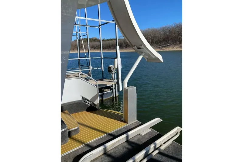 Slide: The Image of Houseboat deck with wooden flooring, Summerset 21' x 106', 2007 model, docked by a lake. - 177