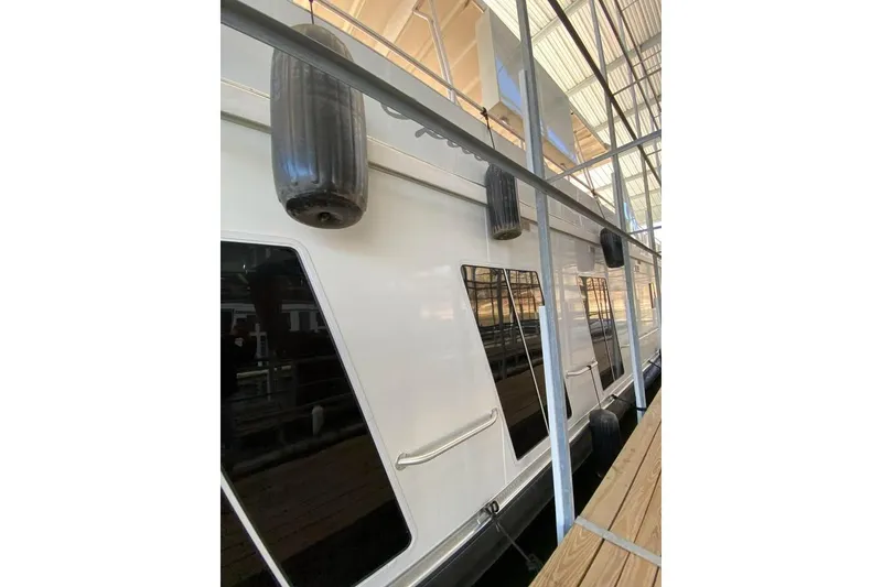 Slide: The Image of 2007 Sumerset Houseboat 21' x 106' docked near a scenic shoreline. - 2