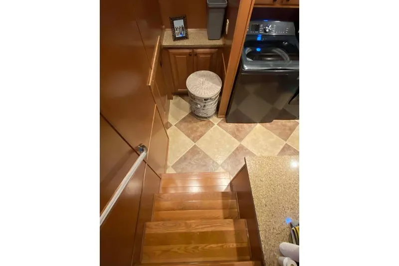 Slide: The Image of Laundry room with modern washer, dryer, wooden cabinets, and a laundry basket. - 235