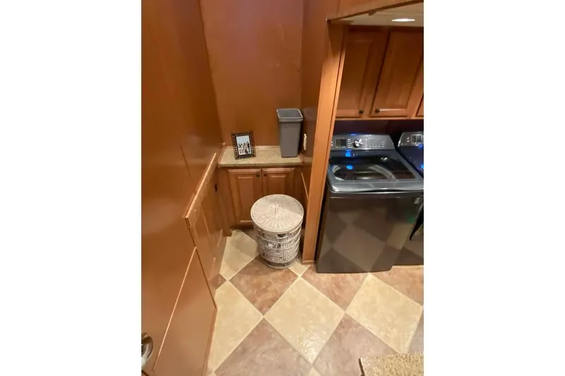 Slide: The Image of Staircase leading to laundry area in 2007 Summerset houseboat, featuring washer and storage. - 238