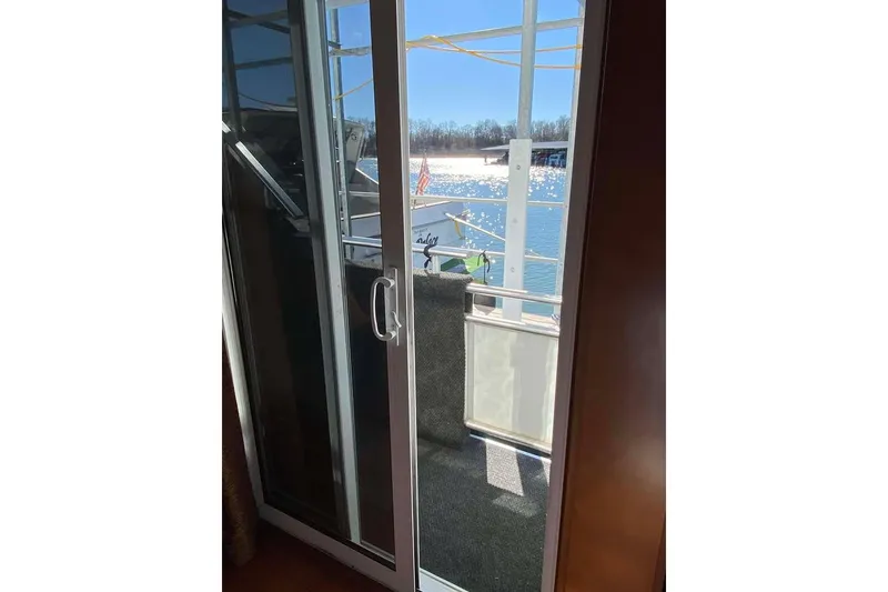Slide: The Image of Interior view of 2007 Summerset houseboat, featuring wood paneling and a window with water view. - 327