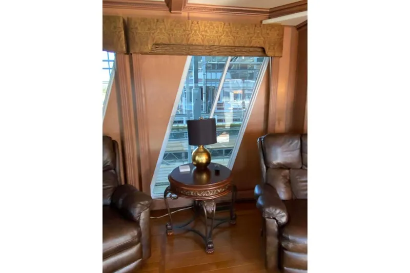 Slide: The Image of Elegant wooden side table with ornate legs, featuring a gold lamp, in a Summerset 2007 model interior. - 338