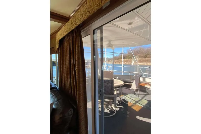 Slide: The Image of Interior view of 2007 Summerset houseboat, showing a sliding door and outdoor seating area. - 350