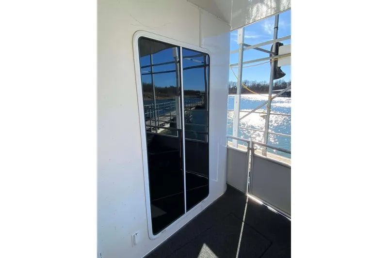 Slide: The Image of Summerset 21' x 106' 2007 houseboat with reflective glass door, overlooking sunny waterfront. - 373