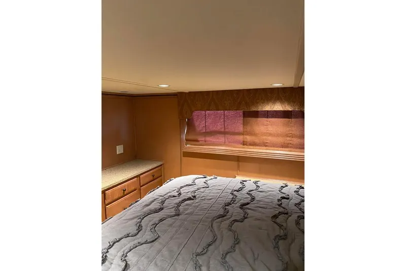 Slide: The Image of Interior of 2007 Summerset model, featuring a cozy bed and wooden cabinetry. - 38