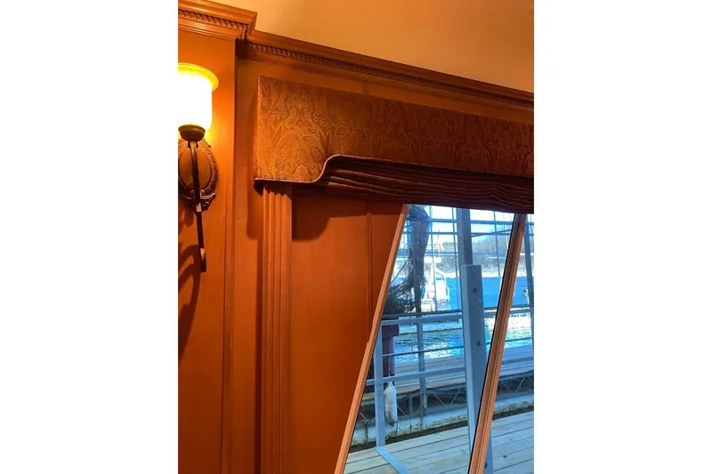 Slide: The Image of Wooden double pantry doors with classic panel design, featuring a thermostat and light switches nearby. - 46