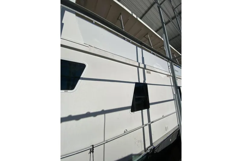 Slide: The Image of 2007 Summerset houseboat, 21' x 106', docked under a covered marina. - 83