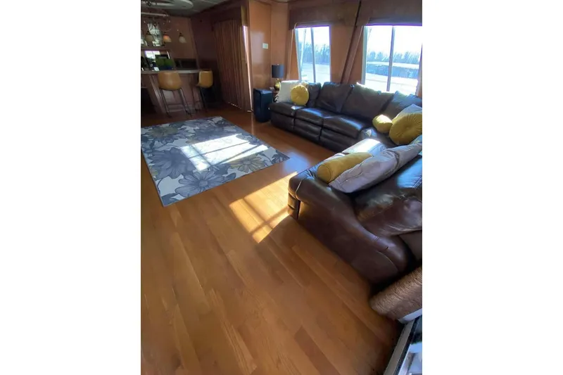 Slide: The Image of Outdoor seating area on a 2007 Summerset houseboat, overlooking a serene lake and wooded shoreline. - 93