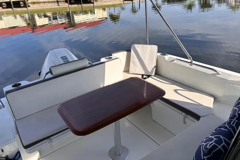 Slide: The Image of 2021 Beneteau Antares 8 boat interior with seating and table by the water. - 11