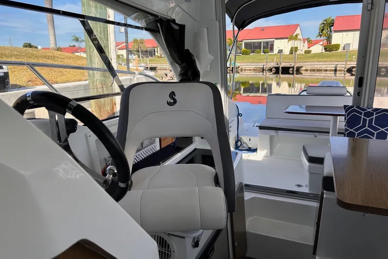 Slide: The Image of Interior of 2021 Beneteau Antares 8 boat with helm and seating area. - 16