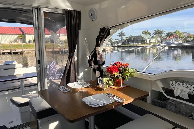 Slide: The Image of Interior of 2021 Beneteau Antares 8 with dining setup and waterfront view. - 19