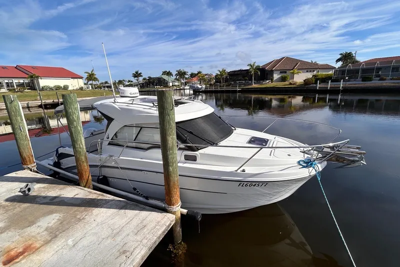 Slide: The Image of 2021 Beneteau Antares 8 docked in a serene marina setting. - 2