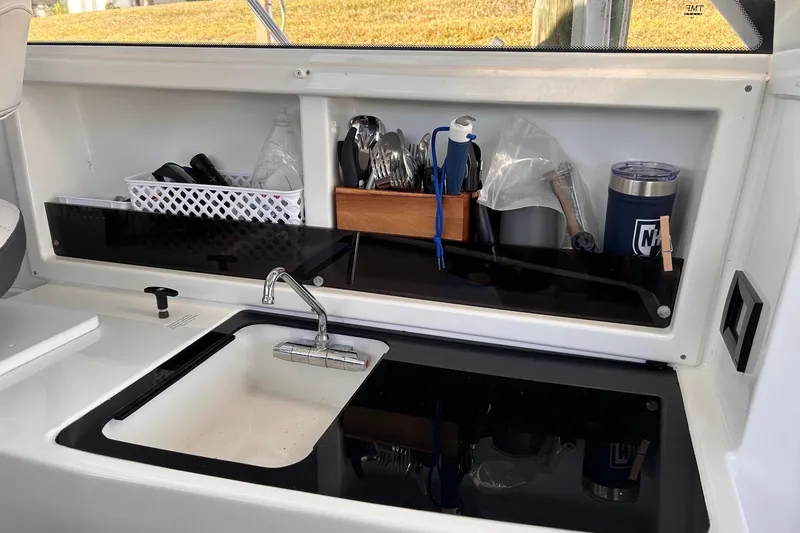 Slide: The Image of Compact kitchen area in 2021 Beneteau Antares 8 with sink and storage. - 25