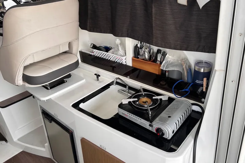 Slide: The Image of Interior of 2021 Beneteau Antares 8 with compact kitchen and seating area. - 27