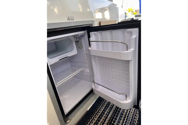 Slide: The Image of Open refrigerator inside 2021 Beneteau Antares 8 boat, showcasing storage space. - 29