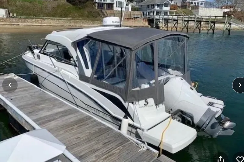 Slide: The Image of 2021 Beneteau Antares 8 docked, featuring a covered cockpit and outboard motor. - 3