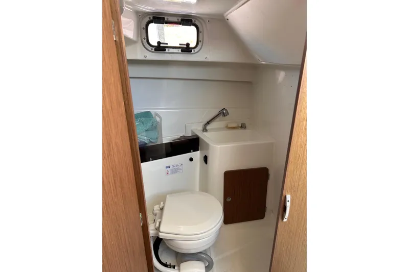 Slide: The Image of 2021 Beneteau Antares 8 boat bathroom with toilet, sink, and window. - 30