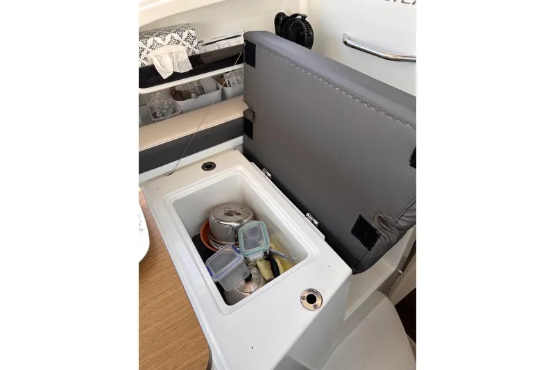Slide: The Image of Interior storage compartment in a 2021 Beneteau Antares 8 boat, containing kitchenware. - 36