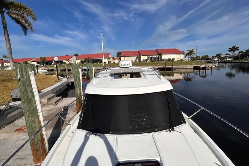 Slide: The Image of 2021 Beneteau Antares 8 docked at marina, clear sky, waterfront view. - 4