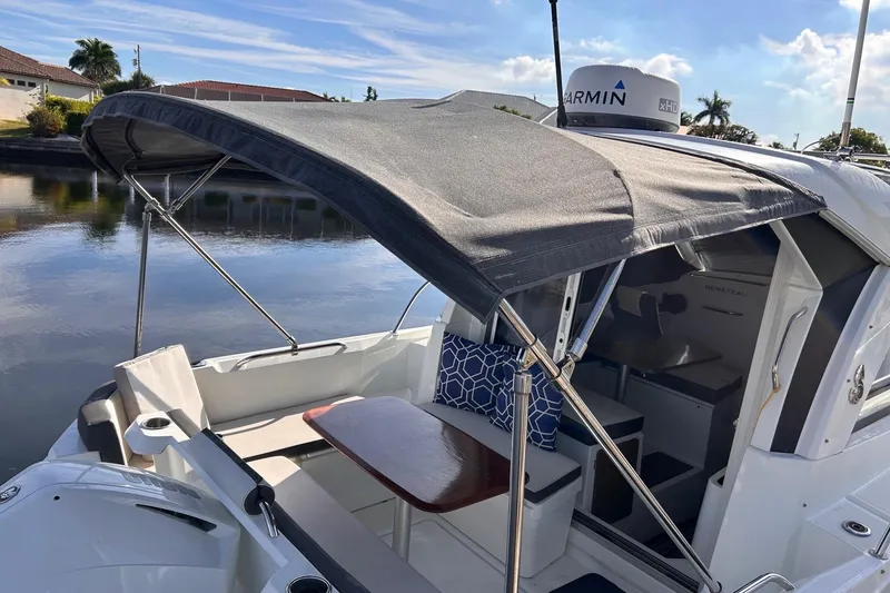 Slide: The Image of 2021 Beneteau Antares 8 boat with canopy, docked by calm waters. - 9