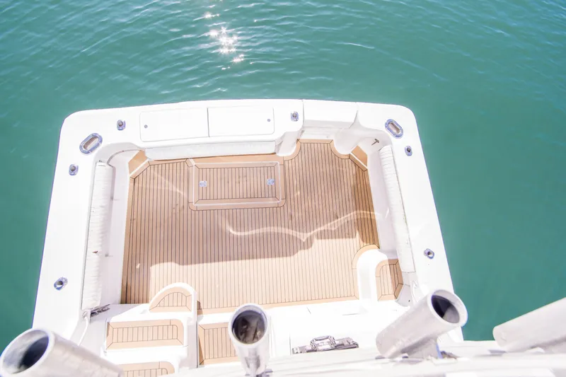 Slide: The Image of 2002 Luhrs 36 Convertible boat deck with teak flooring, overlooking calm blue water. - 11