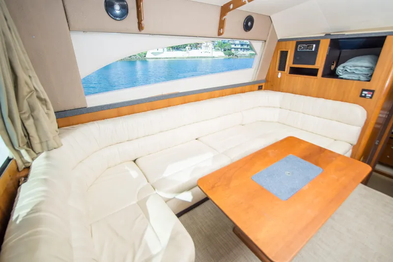 Slide: The Image of Interior of 2002 Luhrs 36 Convertible yacht with beige seating and wooden table. - 12