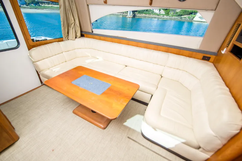 Slide: The Image of Interior of 2002 Luhrs 36 Convertible yacht with cream leather seating and wooden table. - 13