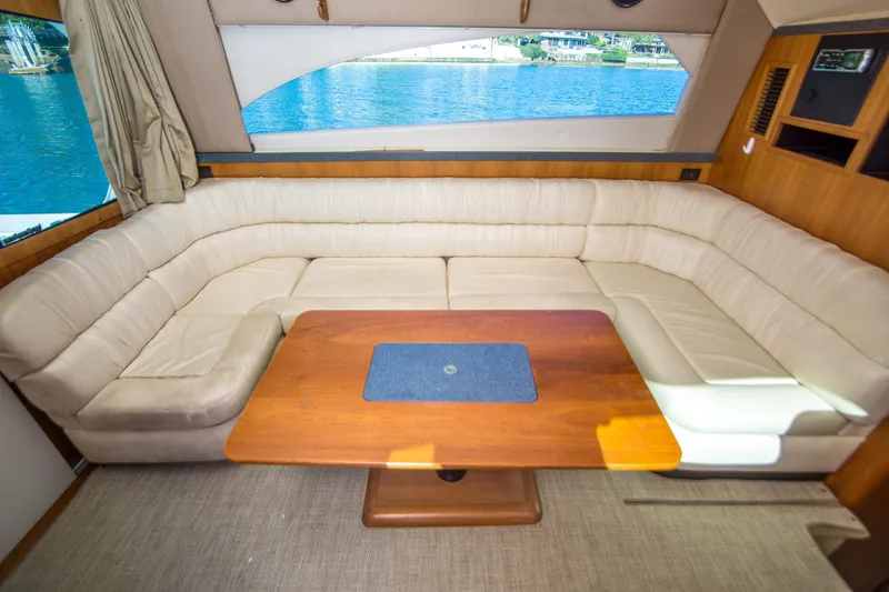 Slide: The Image of Interior of 2002 Luhrs 36 Convertible yacht with beige seating and wooden table. - 14
