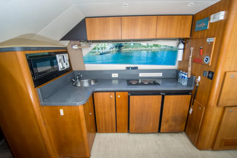 Slide: The Image of 2002 Luhrs 36 Convertible yacht kitchen with wood cabinets and ocean view window. - 16