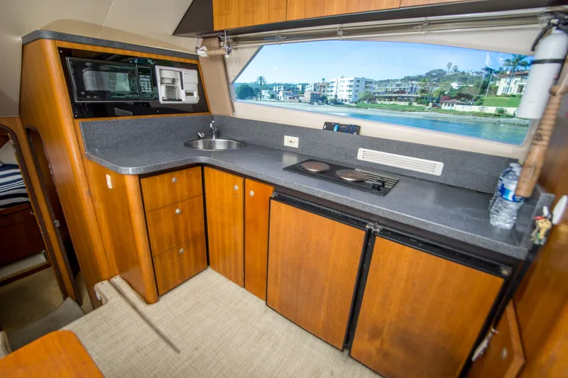 Slide: The Image of 2002 Luhrs 36 Convertible yacht kitchen with wood cabinets and modern appliances. - 17