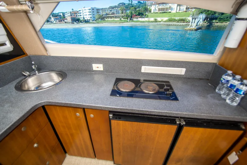 Slide: The Image of 2002 Luhrs 36 Convertible yacht kitchen with sink, stove, and waterfront view. - 20